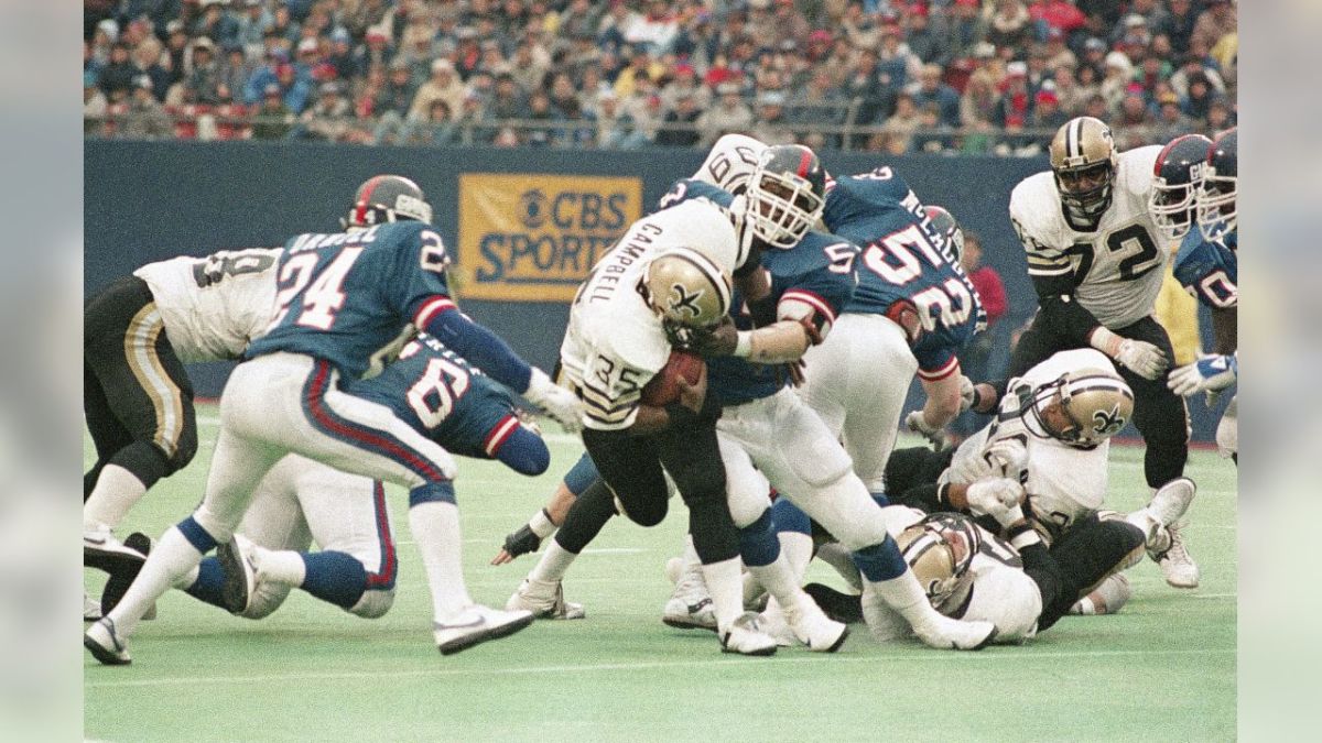 Former New Orleans Saints RB Earl Campbell (35) is stopped by Giants LB Lawrence Taylor during a 1985 game. Credit: Giants.com